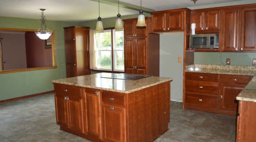 Spacious kitchen with granite countertops and dining room area